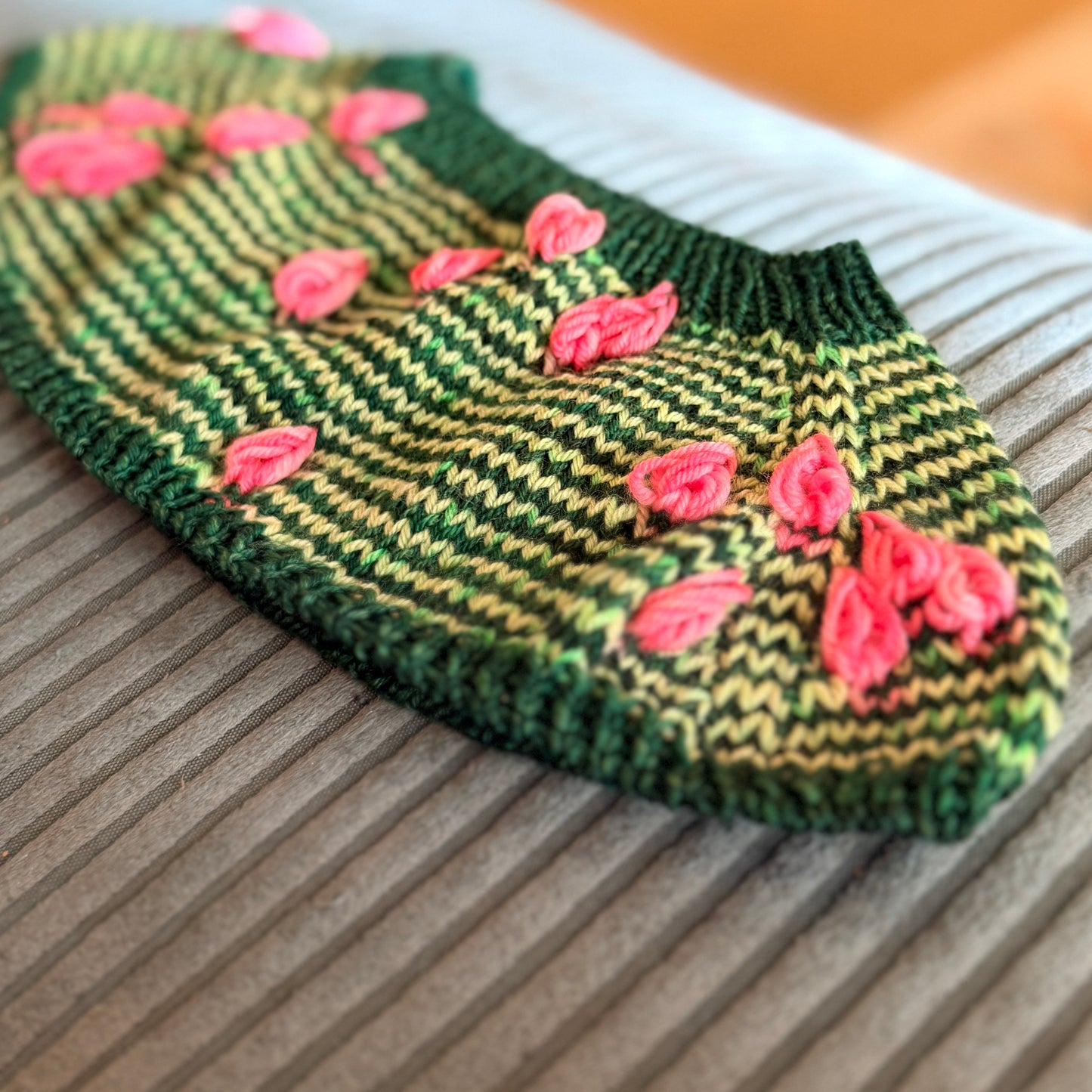 Knitted yoke of the Flack Sock pattern with alternating rows of Pink Tulips and green Budapest yarn