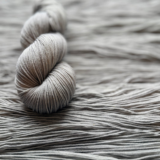 Ball of gray yarn on a textured surface