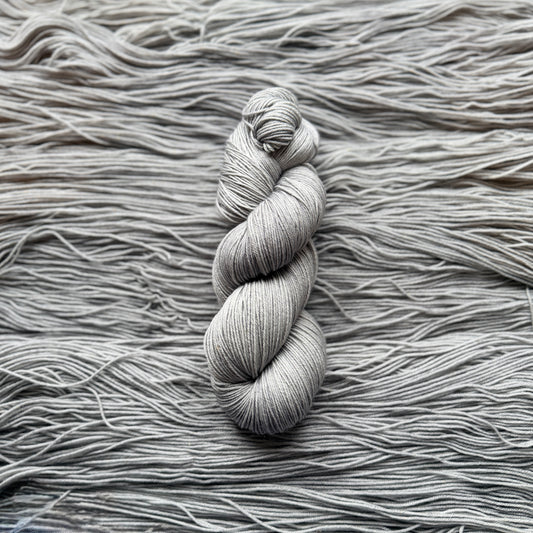 Gray skein of yarn on a textured gray background