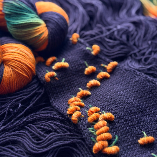 Pumpkin Patch Noir hand-dyed assigned pooling merino sock yarn skein, black base with orange pumpkin motif