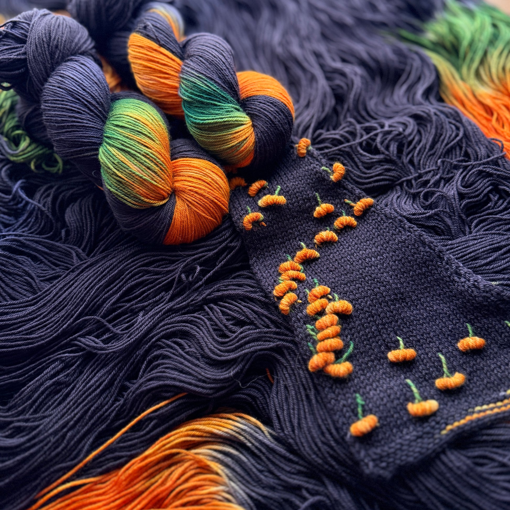 Pumpkin Patch Noir assigned pooling yarn skein, close-up of colourway